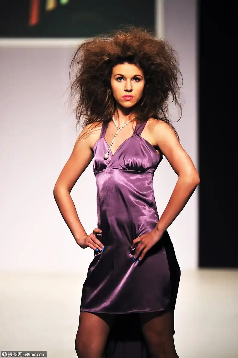 轻漂亮的模特走时装秀上连衣裙姿势