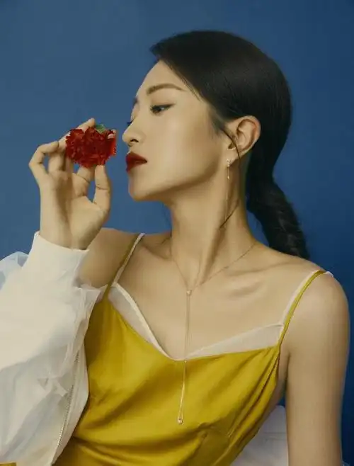 她是包贝尔妻子包文婧穿黄色吊带秀香肩手拿花朵风情万种