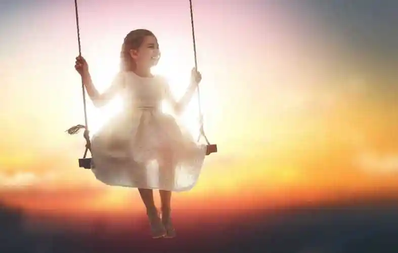 欢笑的女孩女孩在秋日秋千上荡秋千