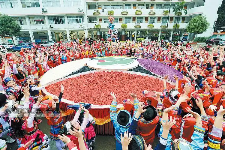 围着一个盛满五色糯米饭的巨大"绣球",庆祝"壮族三月三"传统节日