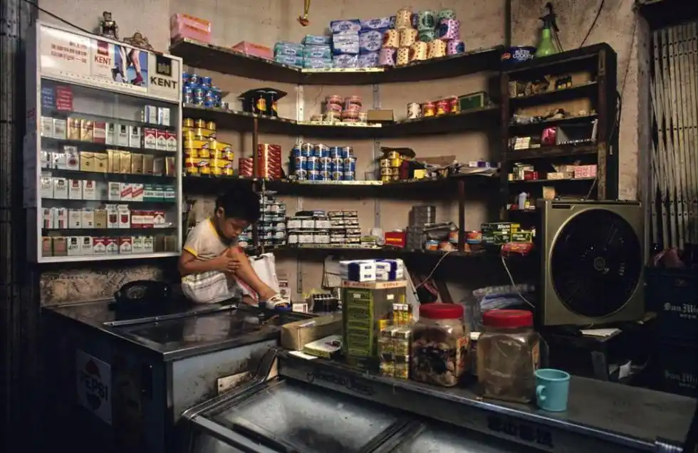 1990年:小卖部里的男孩正在看店.