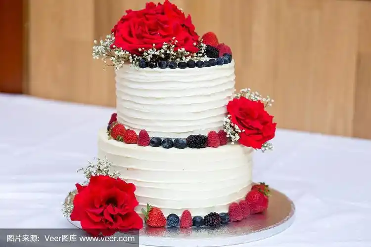 两层生日奶油和浆果蛋糕,装饰新鲜的红玫瑰,白色和红色调色板,特写