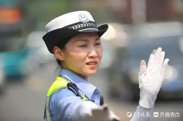 高考考点外女交警烈日下护送考生入场