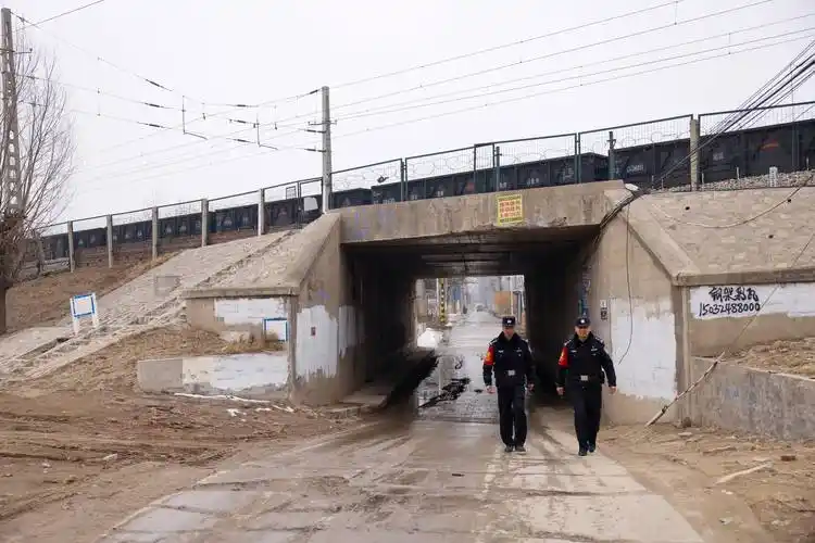 图为石家庄铁路公安处河间西站派出所民警景国杰与同事在线路涵洞附近