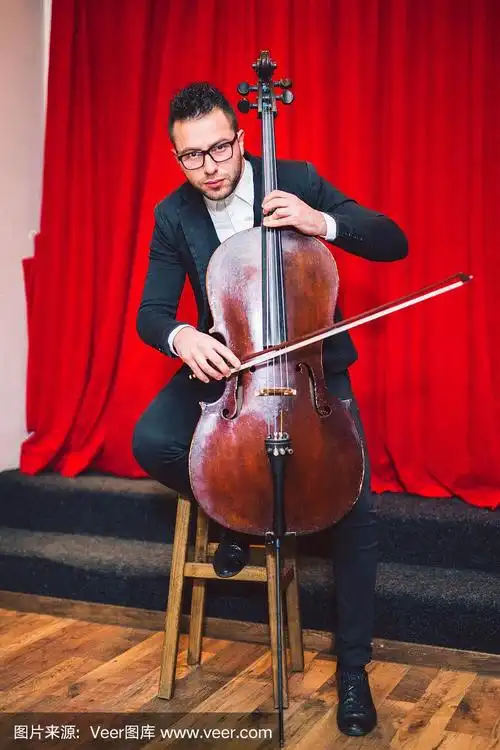 男子在舞台上用大提琴演奏古典音乐.