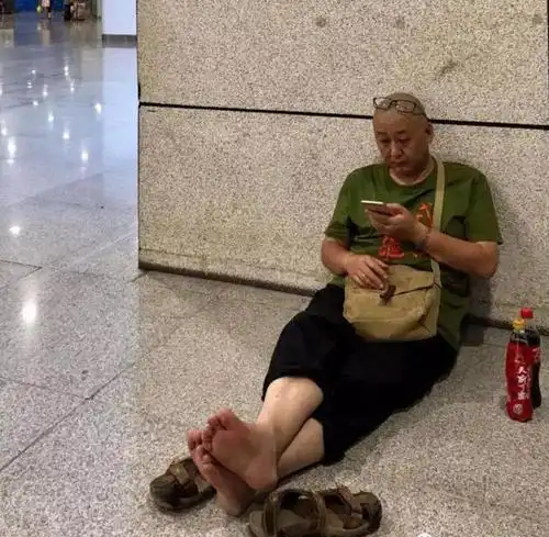 头条,有不知情的网友很好奇,这不就是一位光脚坐在火车站的邋遢老头嘛