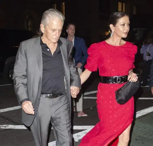 凯瑟琳泽塔琼斯穿红色长裙现身庆生 和老公道格拉斯牵手恩爱十足