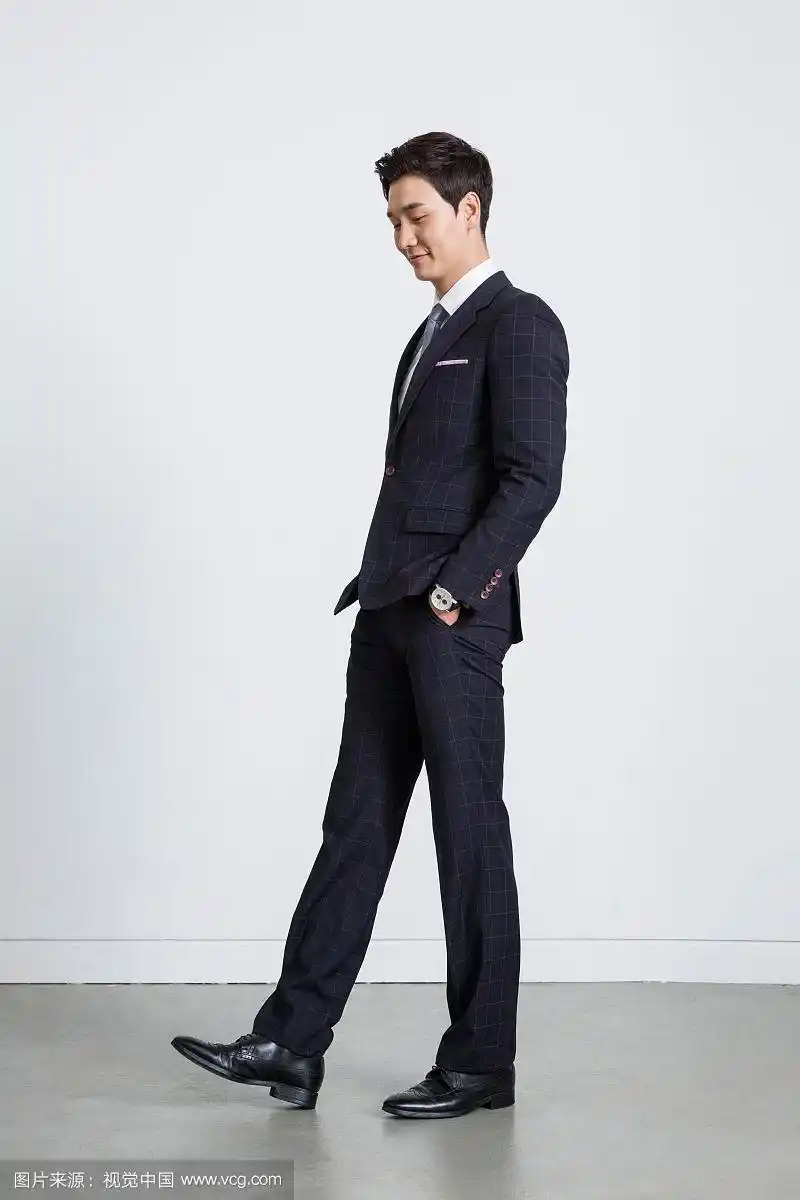 穿着西装的男人站着举着手势的照片