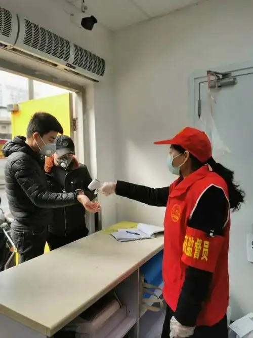 区法院志愿者为配送人员测量体温