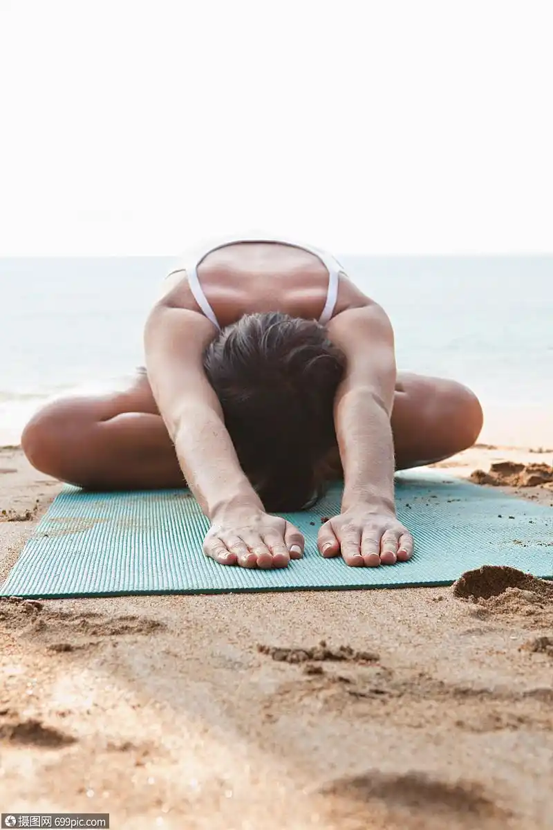 在海滩上练习瑜伽的女人一个人外国人