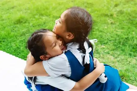 旧金山姐妹学校两个小亚洲女孩姐妹拥抱快乐的帖子在校服, 回到学校