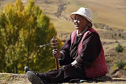手拿转经筒的西藏老人