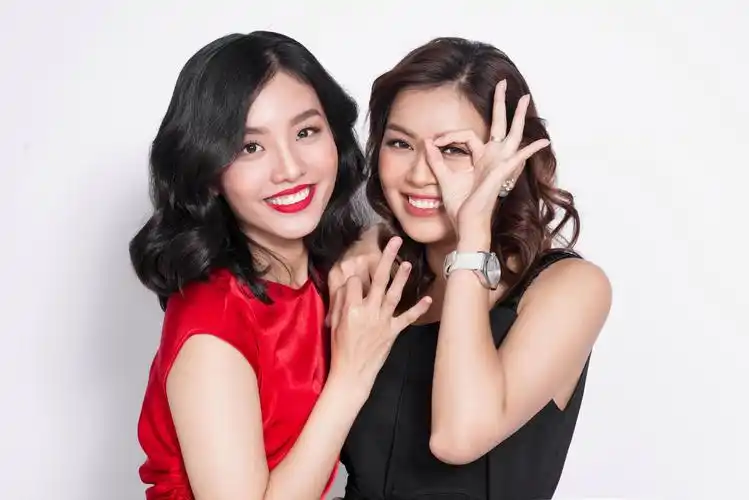 两个快乐年轻美女在白色背景上的衣服