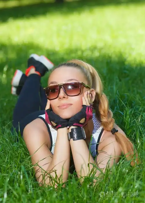 美丽的女运动微笑躺在草地上照片-正版商用图片1ftvoj-摄图新视界