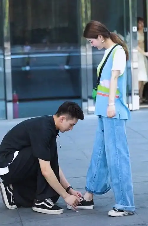 男孩超宠女友出门帮女友系鞋带不过好像他家小孩不听话