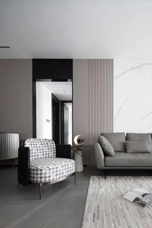 沙发背景墙由清晰纹理的浅色岩板 灰咖色木格栅及硬包构成,其上不再以