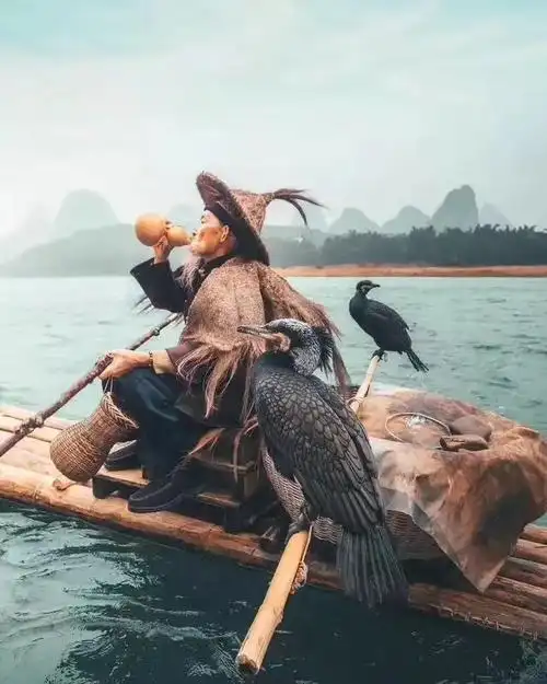 漓江鱼翁 竹筏鱼鹰河水清,斗笠蓑衣老翁挺