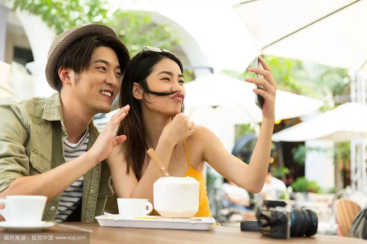 浪漫情侣在户外咖啡馆喝咖啡使用手机视频聊天