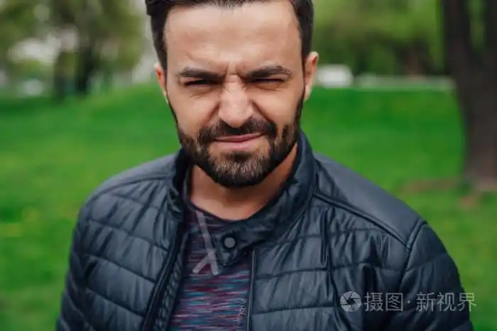 眯着眼睛太阳他的眼睛因为一个年轻男人的肖像