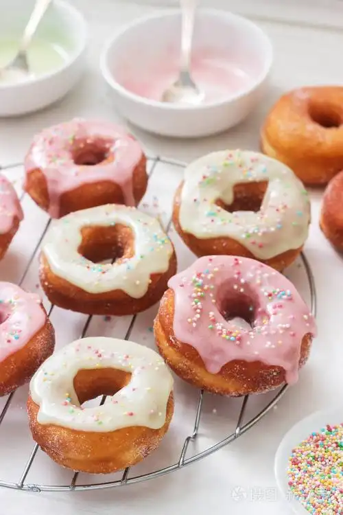 自制甜甜圈, 在浅色背景上装饰有彩色糖霜和有色糖