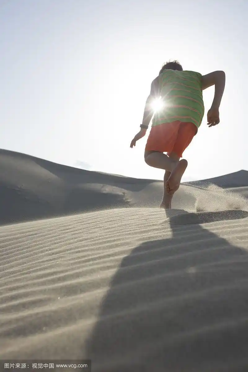 美国加州死亡谷国家公园,男孩在沙漠沙丘上奔跑的背影