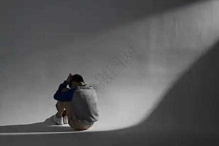 蜷缩在墙角照片  |孤独自闭的青少年遭受校园暴力坐在角落特写模板