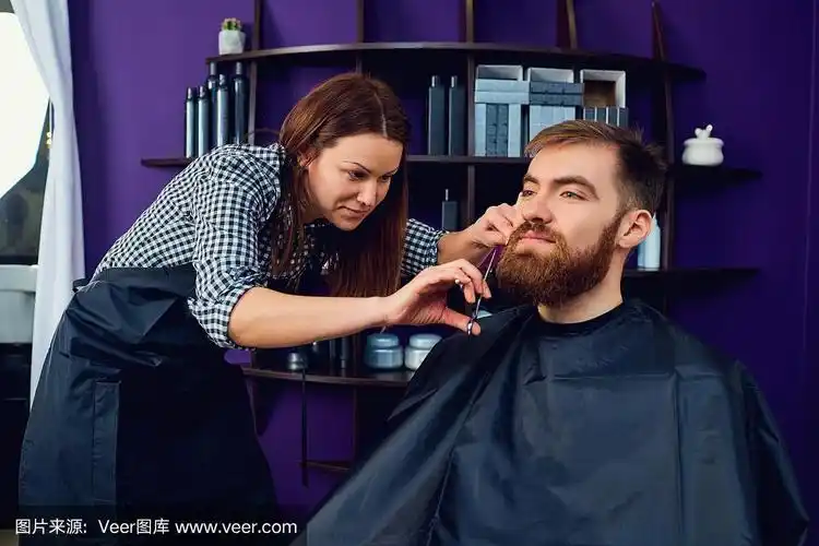 一个女理发师在美容院给男人剪胡子