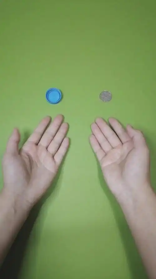 魔术#硬币是怎么转移到拿瓶盖那只手上的?