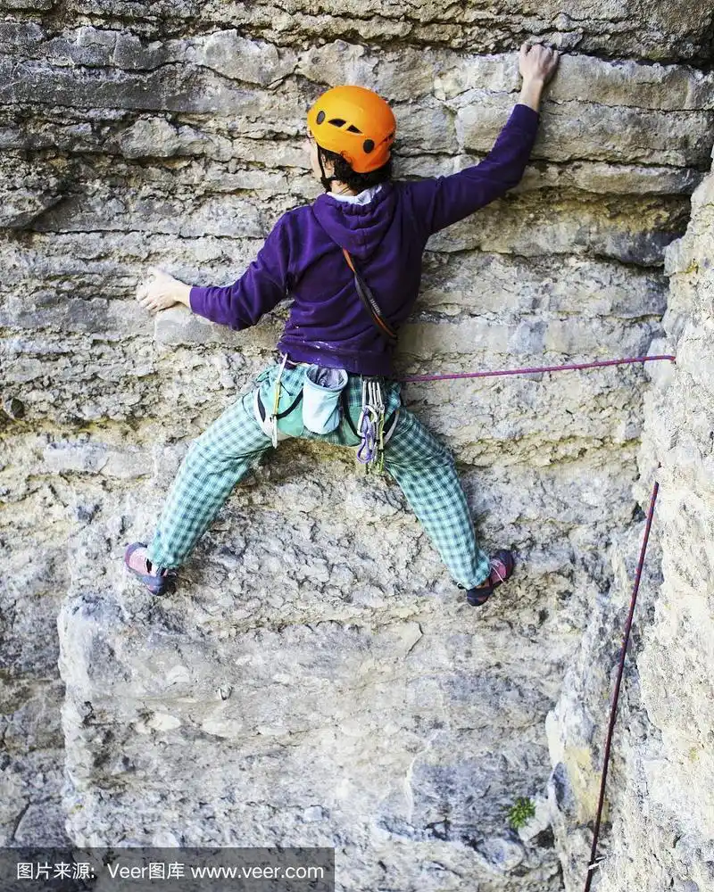 攀岩者在岩壁上攀岩.男人总是采取艰难的行动.