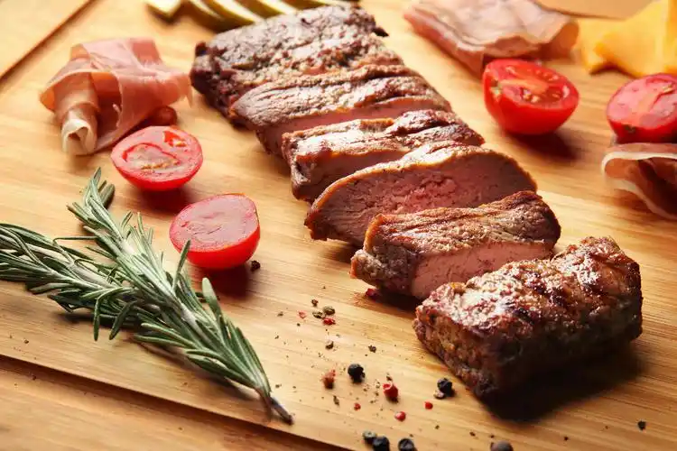 烤的牛排和在砧板上的开胃菜摄影图西餐牛排