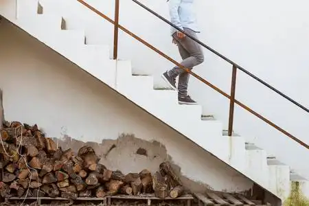 而年轻的女子去 downst 下楼梯, 堆放着木树干照片