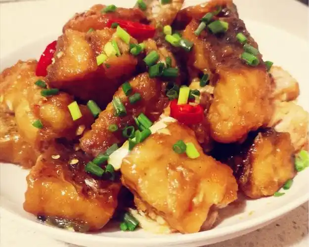 翻炒均匀,最后撒上白芝麻和葱花,出锅装盘,酸甜开胃的糖醋鱼块就