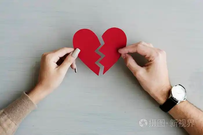 双手捧着破碎的纸心原始照片