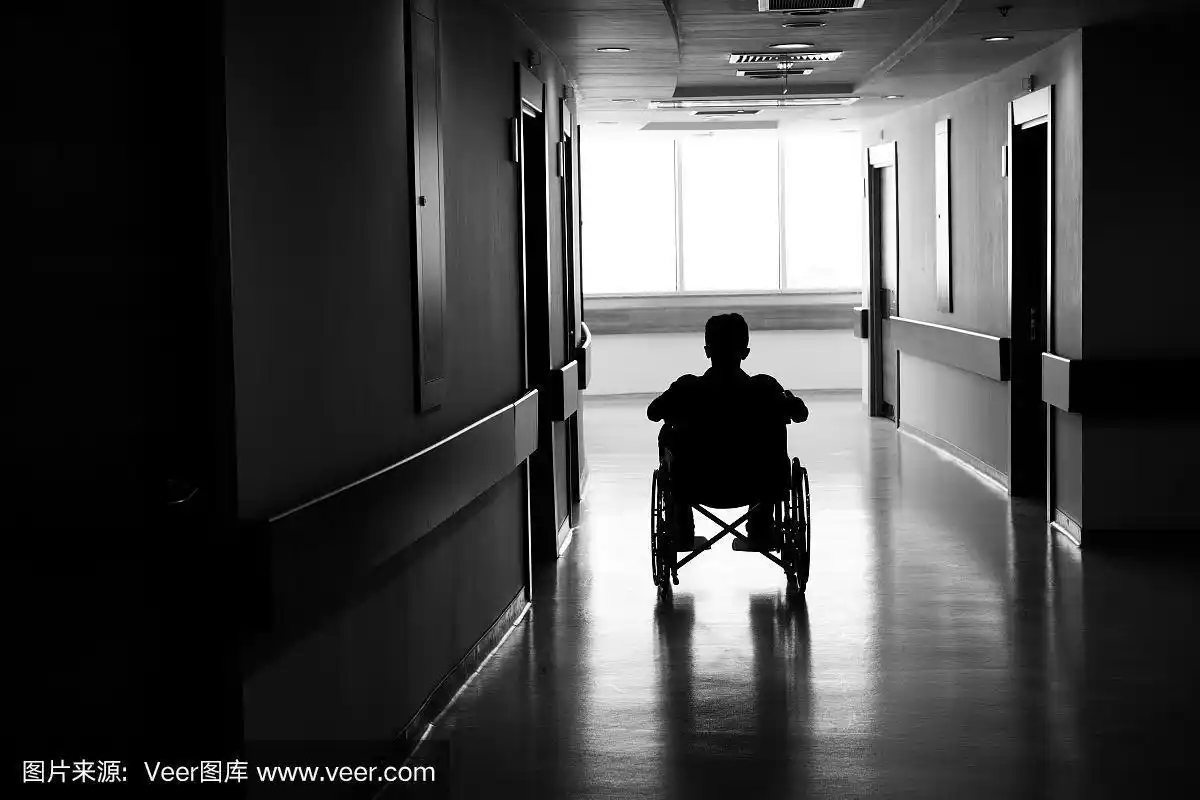 在黑暗的走廊里,一个坐在轮椅上的人的剪影
