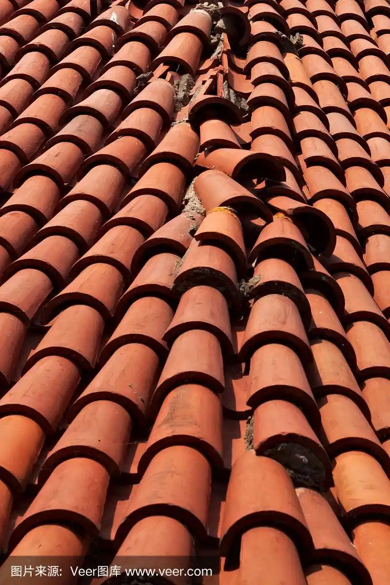 屋顶上铺着破旧的红瓦片.