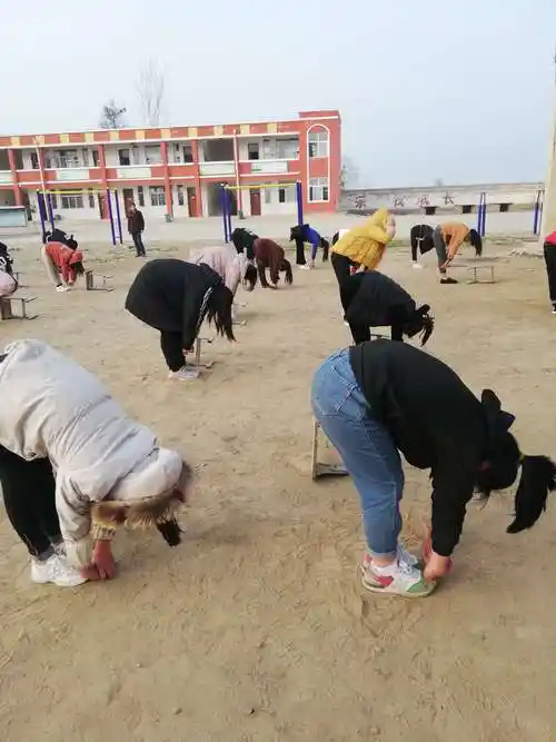 学生把腿绷直,尽最大努力往下弯腰,是为锻炼学生的坐位体前屈!