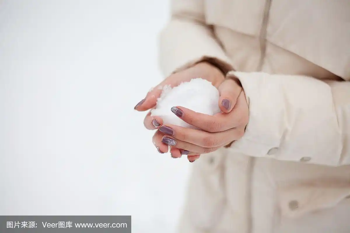 美丽快乐的女孩手捧雪在冬天的户外