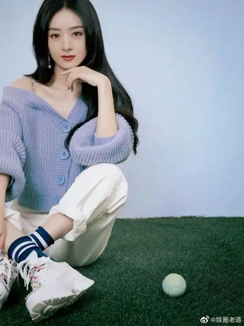 赵丽颖 身穿紫色露肩毛衣,搭配白色牛仔裤与运动鞋,歪头甜笑