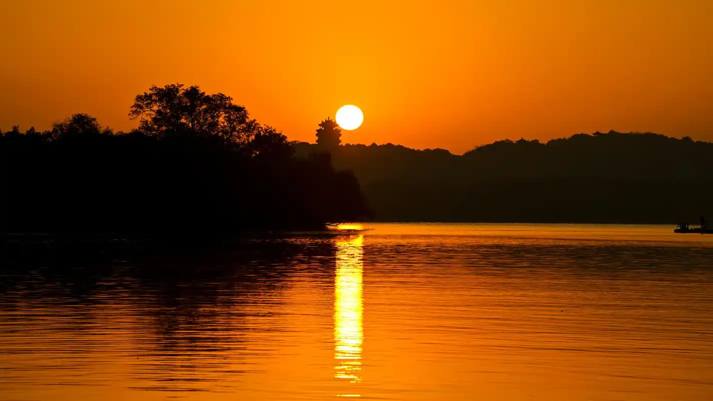 照苏堤日出》初冬清晨,一轮红日绕着城隍阁徐徐升起,红色霞光铺满湖面