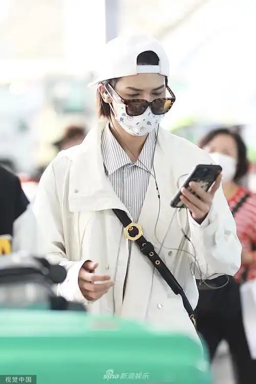 组图:朱正廷反戴棒球帽潮范儿足 低头看手机模样呆萌