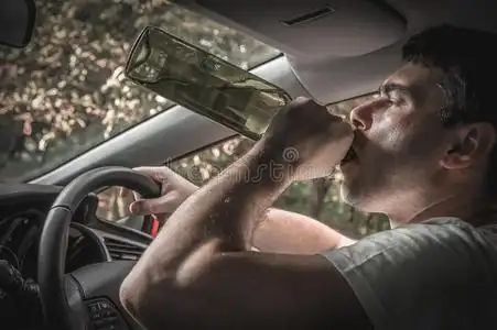 醉的驾驶员和瓶子关于葡萄酒操纵一c一r照片