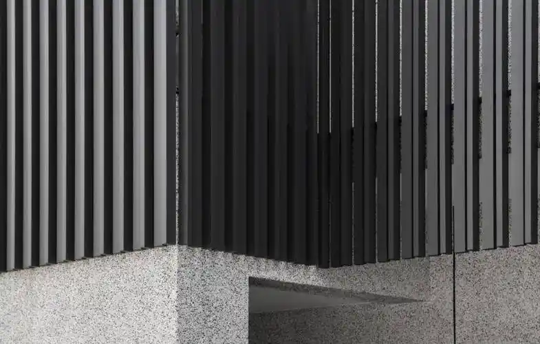 建筑物的外部採用方形水泥空心砖,抿石子和深灰色铝格栅,勾勒出一个长