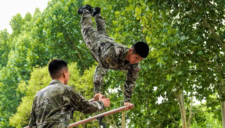 图为参考官兵进行双杠三练习课目考核
