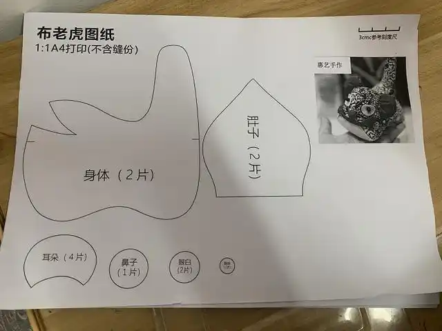坐在工作台前,拿着一个即将制作完成的布老虎,全神贯注地进行最后的