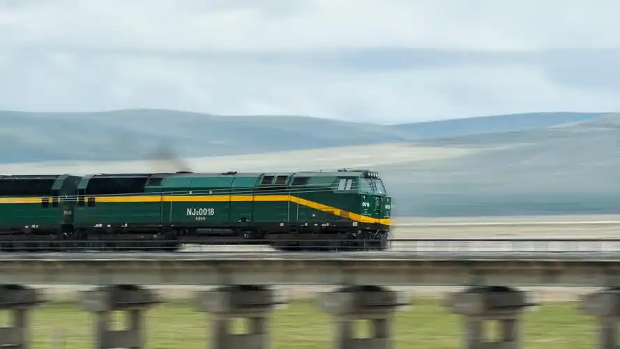 青藏高原上独有的nj2型内燃机车隆隆驶过草原上的桥梁,奔向