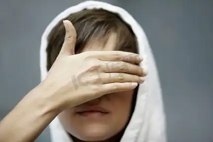 十几岁的女孩用手遮住眼睛,选择性聚焦在前景上头发手