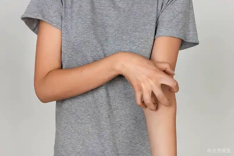 女孩_灰色_衬衫_挠_手臂_刮蹭_手_上方_灰色背景_高清图片_全景视觉