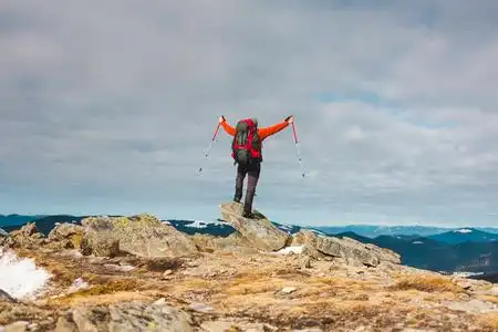 一个人上了山,人们穿过美丽的荒野,爬上了山顶,享受着他的成功.照片