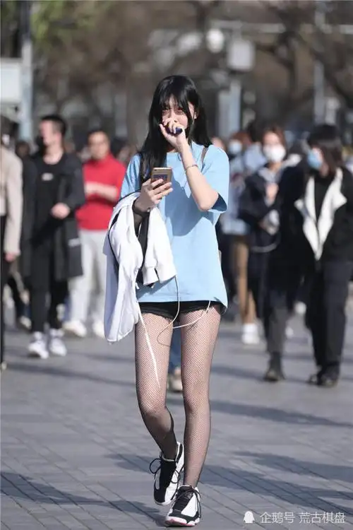 夏初时节穿着黑色丝袜和运动鞋年轻姑娘才会选择的搭配
