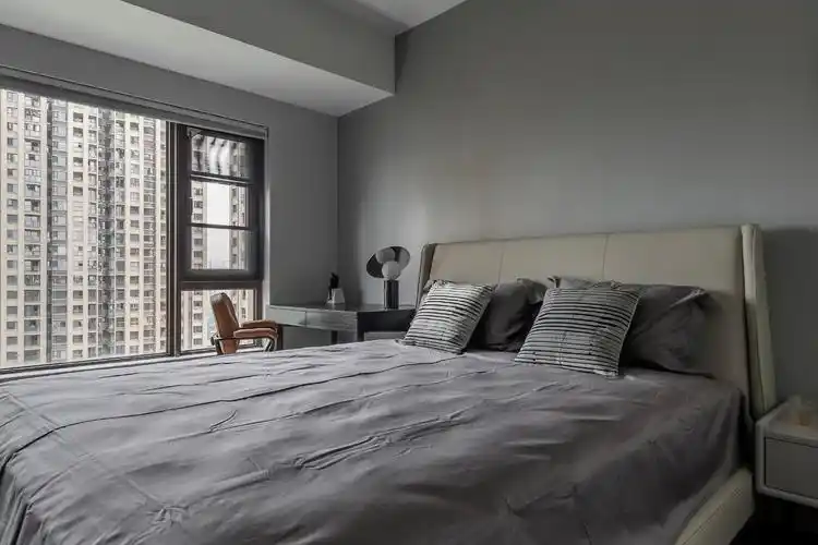 卧室也是以暗灰色的氛围,床头挂一幅横幅黑白画,结合轻盈的窗帘,简洁